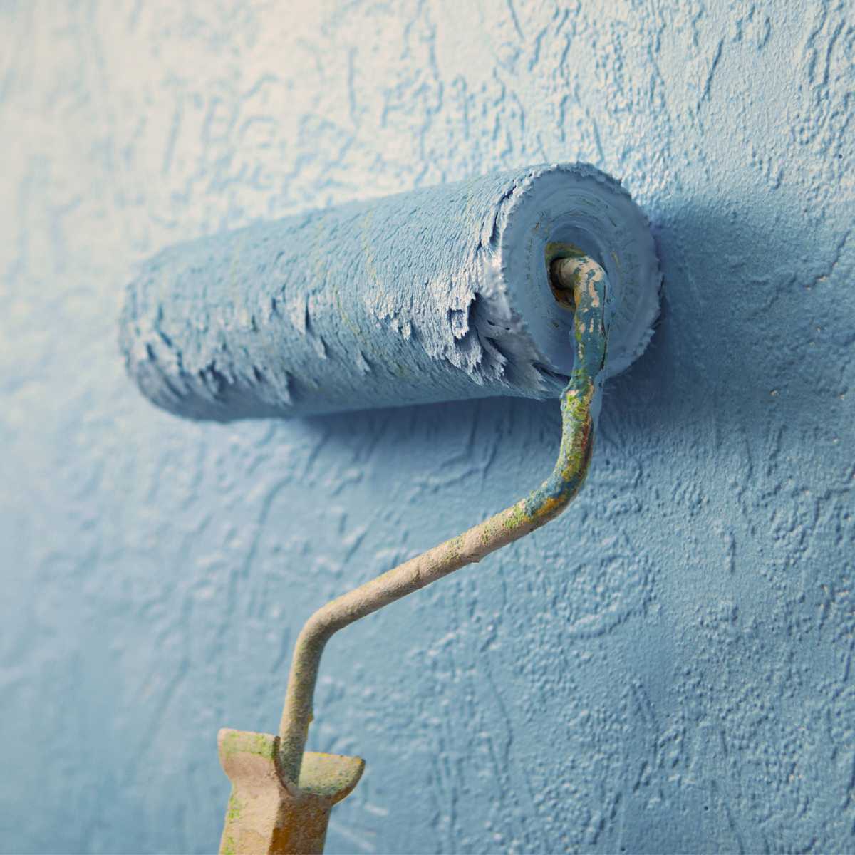 Painting a textured wall with a roller.