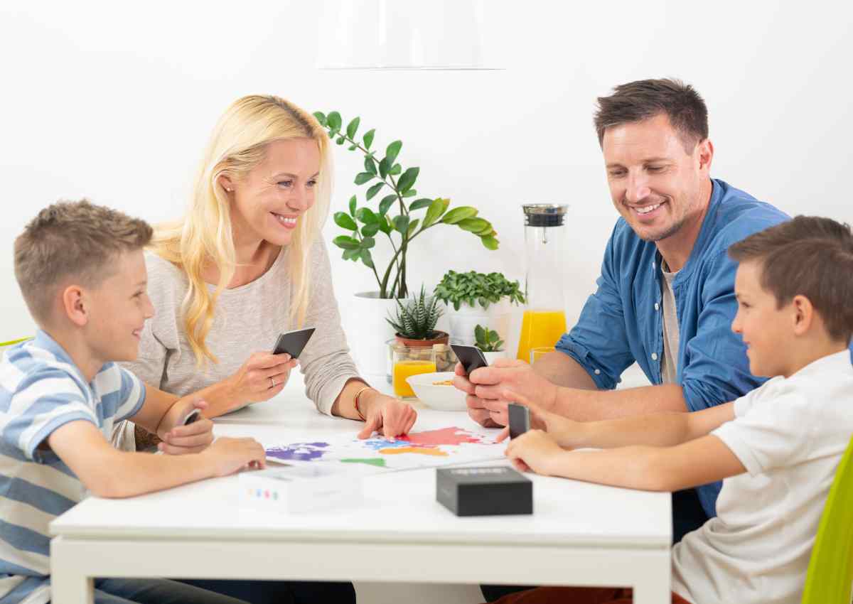 Picture showing a family of 4 playing cards indoor.