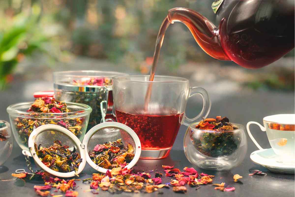 Infused tea pot pouring in the cups.